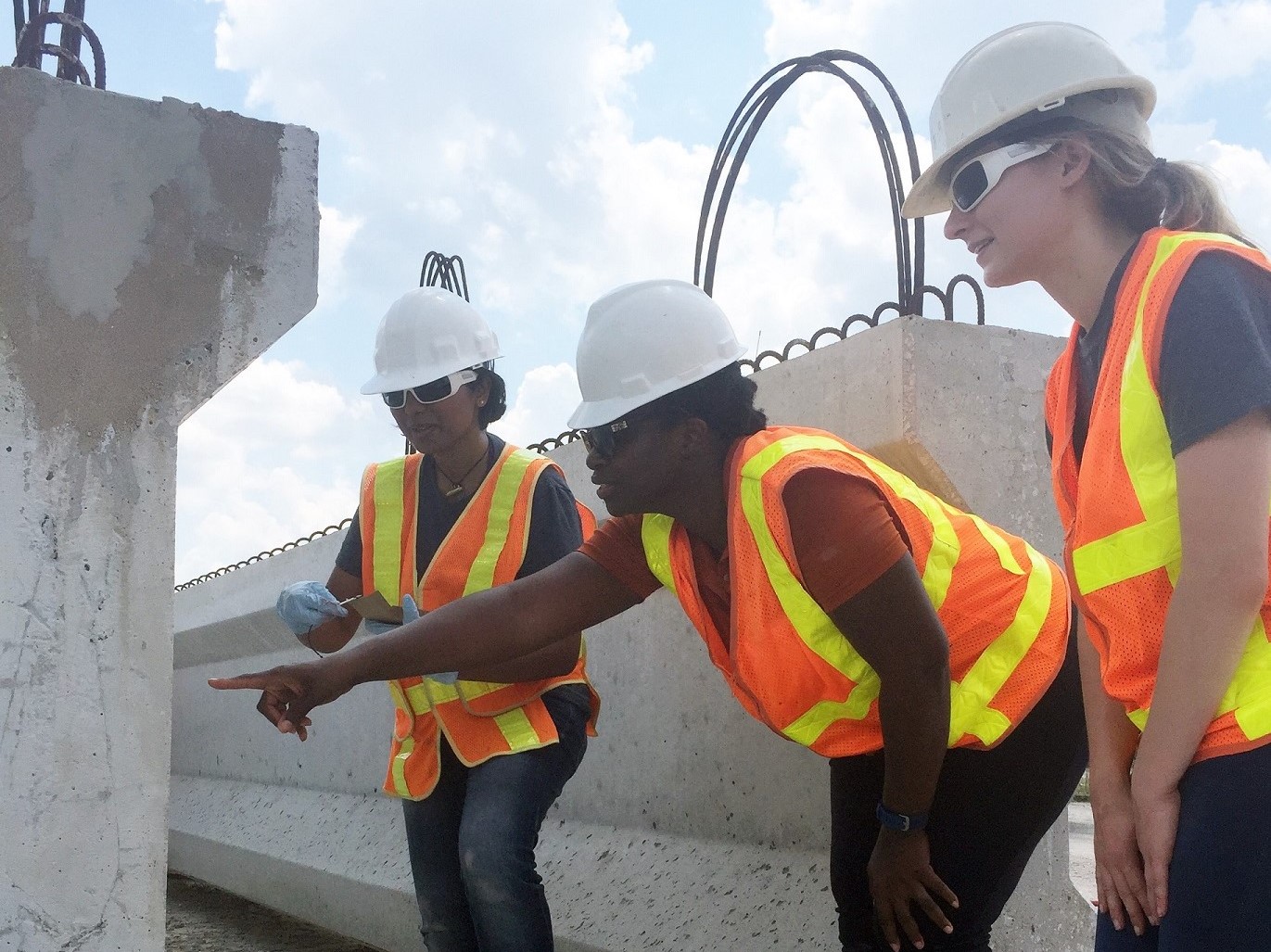 three students looking at concrete structure