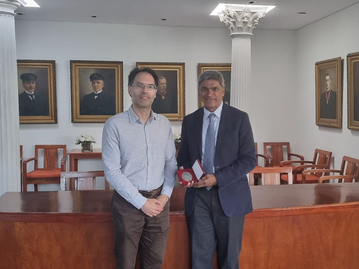Texas CAEE professor Lance Manuel holding award plaque with professor José Correia