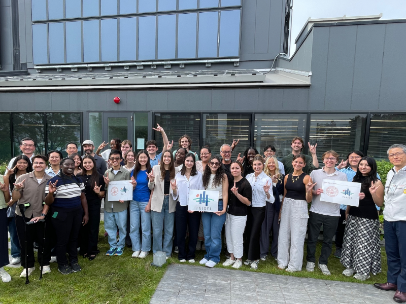 Texas CAE Engineer Gregory Brooks standing outside building with Texas Engineering students