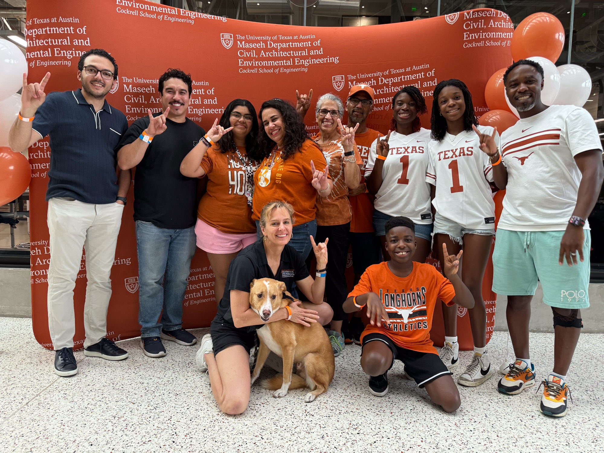 Texas CAEE Alumni Tailgate large group of alumni in front of photo backdrop in the EER building on campus