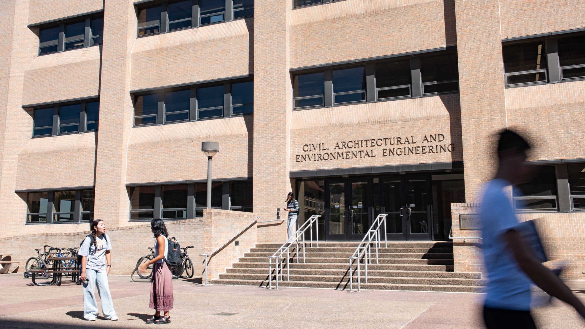 Entrance to CAEE home the ECJ building where students are walking in and out.