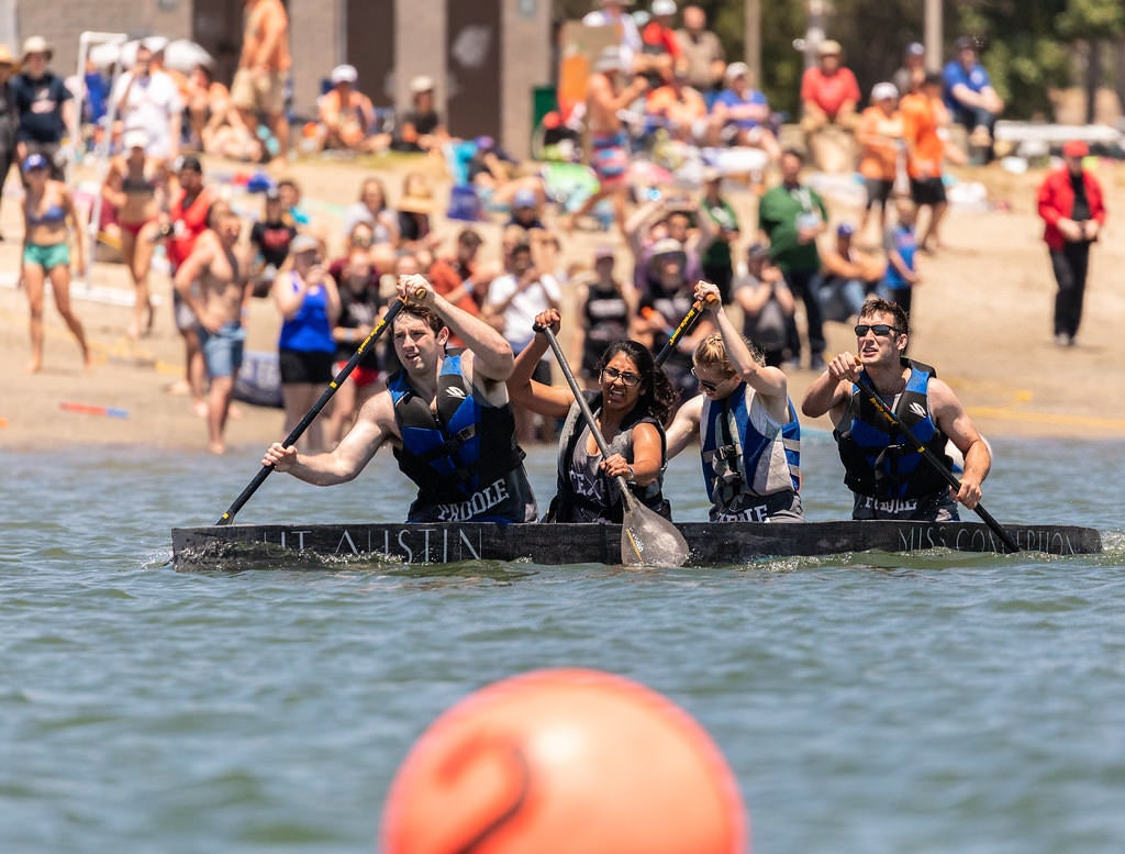 UT Austin students paddling canoes on Lake Austin during competition