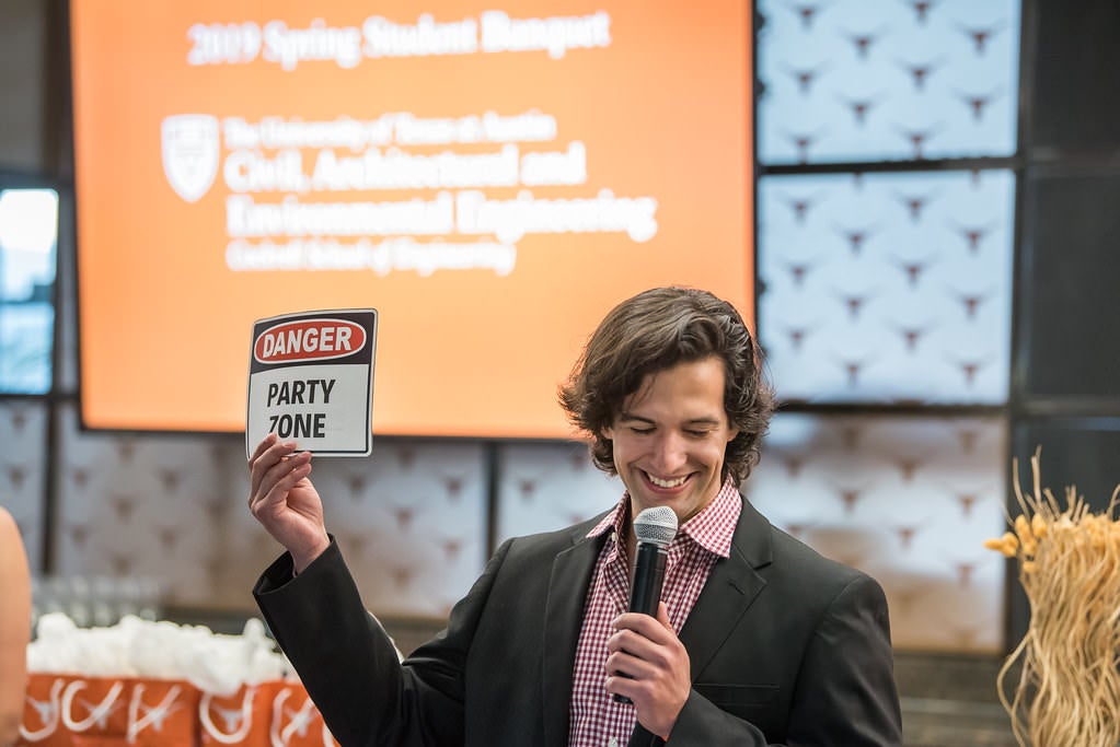 CAEE Student Reception where they hold up Danger Party Zone sign laughing