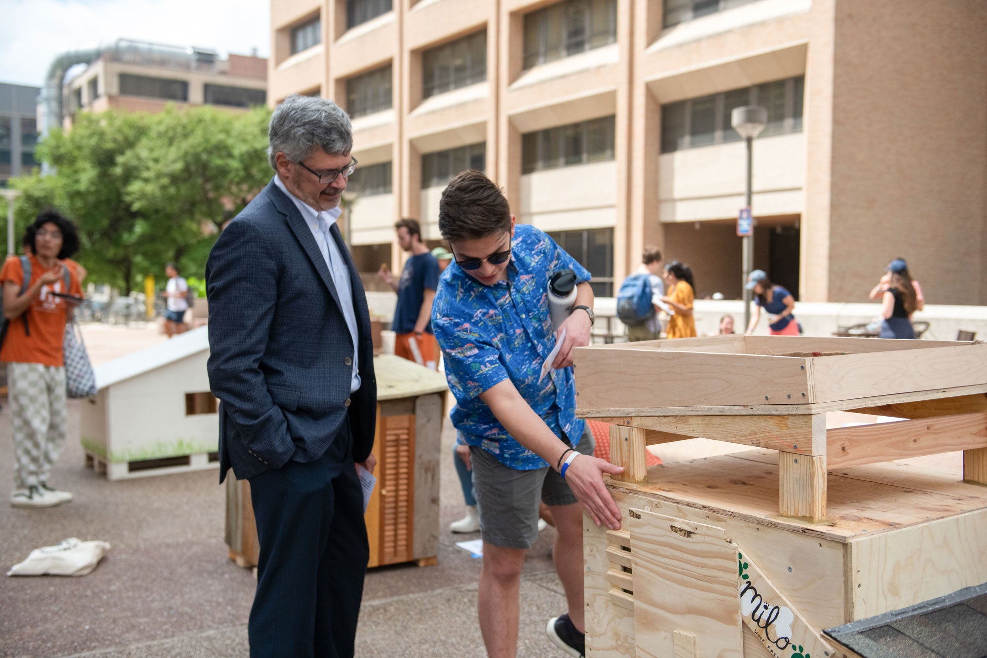 Dean Bonnecaze judging a student entry in the sustainable dog house challenge