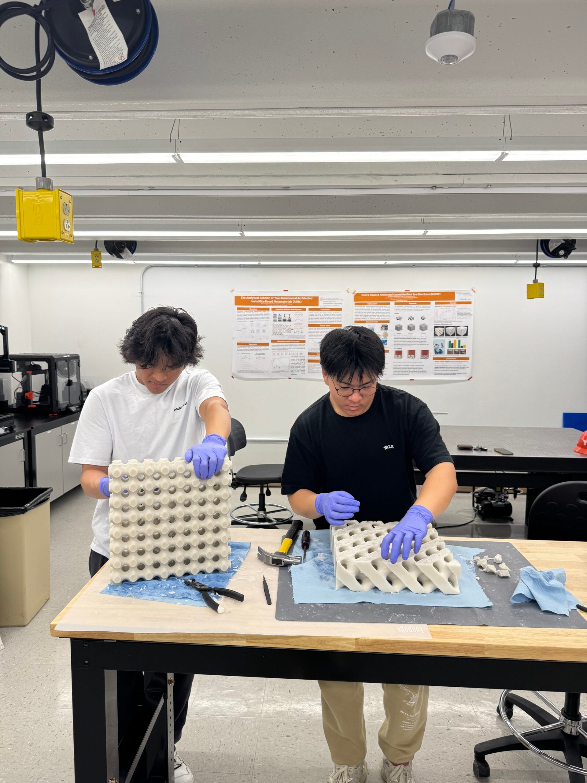 CAEE students Kelvin Nguyen and Darin Pi working in a lab on research prototype