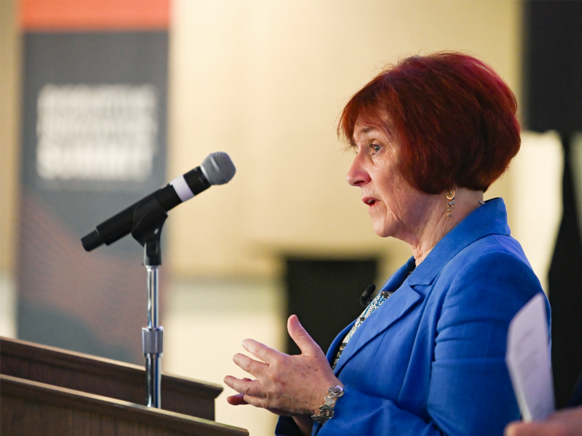 Deborah Brosnan speaking at podium during CAEE's 2026 Disruptive Innovation Summit event.