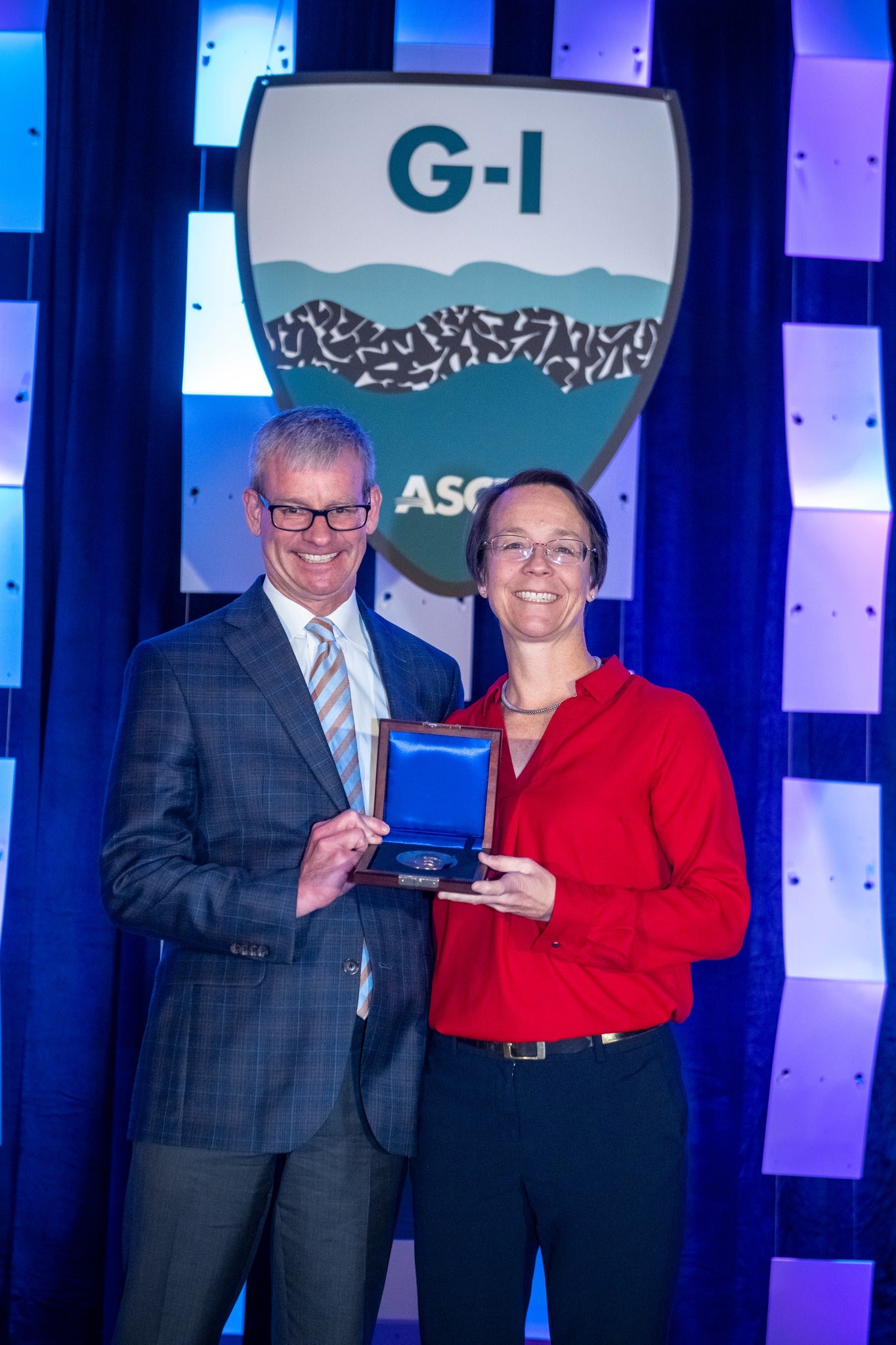 Texas Engineers Ellen Rathje and Bob Gilbert smiling together holding an award.